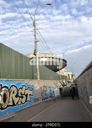 Uno stretto passaggio tra le recinzioni, un sottopassaggio moderno con un tunnel con graffiti informali in una città moderna in una baraccopoli, un quartiere povero. Georgia, Foto Stock