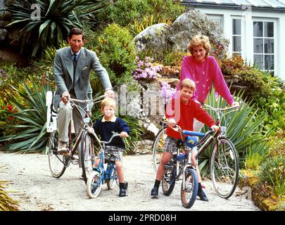 File foto datata 01/06/89 del Principe e della Principessa di Galles con i figli Principe William, a destra, e il Principe Harry che si preparano per un viaggio in bicicletta a Tresco durante le loro vacanze sulle Isole Scilly. Le foto di ogni anno della vita del Re sono state compilate dall'agenzia di stampa PA, per celebrare l'incoronazione di Carlo III. Data di emissione: Giovedì 27 aprile 2023. Foto Stock