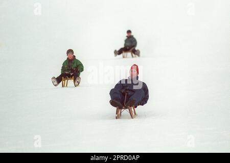File foto datata 06/01/95 del Principe di Galles, seguito dai figli Principe Harry e Principe William, durante una corsa in slittino sulle piste fuori dal loro hotel nella località svizzera di Klosters. Le foto di ogni anno della vita del Re sono state compilate dall'agenzia di stampa PA, per celebrare l'incoronazione di Carlo III. Data di emissione: Giovedì 27 aprile 2023. Foto Stock