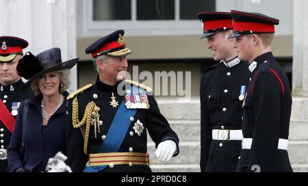Foto del file datata 12/04/06 del Principe di Galles e della Duchessa di Cornovaglia che parla con il Principe William e il Principe Harry prima di lasciare la Sandhurst Royal Military Academy dopo la parata del Sovrano che segnò il completamento dell'addestramento dell'ufficiale del Principe Harry. Le foto di ogni anno della vita del Re sono state compilate dall'agenzia di stampa PA, per celebrare l'incoronazione di Carlo III. Data di emissione: Giovedì 27 aprile 2023. Foto Stock