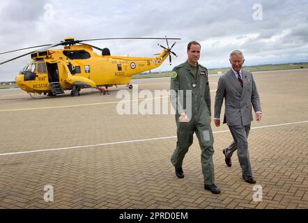 Foto del file datata 09/07/2012 del Duca di Cambridge che mostra il Principe di Galles uno degli elicotteri Sea King che egli capiterà mentre visita la RAF Valley su Anglesey, durante il suo annuale tour estivo del Galles. Le foto di ogni anno della vita del Re sono state compilate dall'agenzia di stampa PA, per celebrare l'incoronazione di Carlo III. Data di emissione: Giovedì 27 aprile 2023. Foto Stock