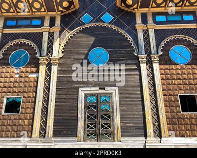 Bella annata antico intagliato porta autentica con finestre con vetro con una struttura forgiata archi e motivi. Lo sfondo. Foto Stock