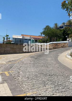 Marciapiede e scale che conducono verso l'alto e verso il basso. Strada di pietra o lastre di pavimentazione. Estate giorno di sole. Foto Stock