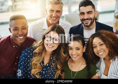 Lavoro di squadra, lavoratori sorridenti e diversificati che si uniscono in un ambiente di lavoro creativo. Ritratto di un gruppo di uomini d'affari occasionali e colleghi che sembrano felici. Team di professionisti pronti per la collaborazione Foto Stock