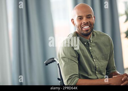 Ho ancora tanto da ringraziarmi: Un giovane seduto in sedia a rotelle a casa. Foto Stock