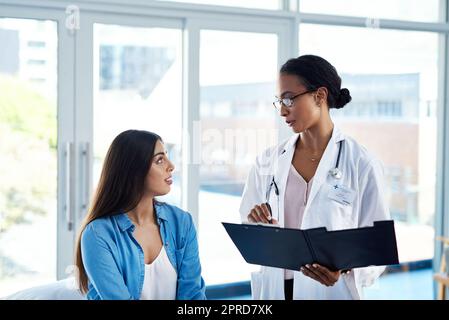 E questo mi farà sentire meglio: Una giovane donna che ha una consulenza con il suo medico. Foto Stock