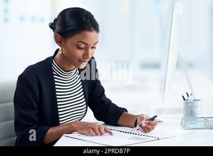 Le persone occupate alla fine si trasformano in persone di successo, una giovane e attraente donna d'affari che va oltre la documentazione all'interno del suo ufficio al lavoro. Foto Stock