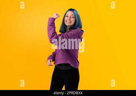 Giovane gilr con capelli blu che fa gesto vincente Foto Stock