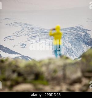 Giovane donna che ammira la bellezza naturale di un ghiacciaio delle Alpi svizzere. Europa Foto Stock
