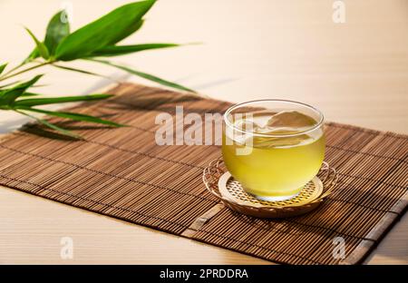 Tè verde giapponese freddo su un tappetino in bambù. Foto Stock