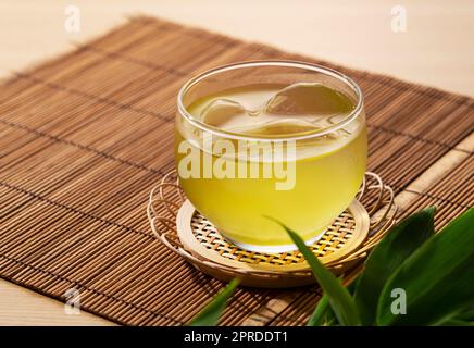 Tè verde giapponese freddo su un tappetino in bambù. Foto Stock