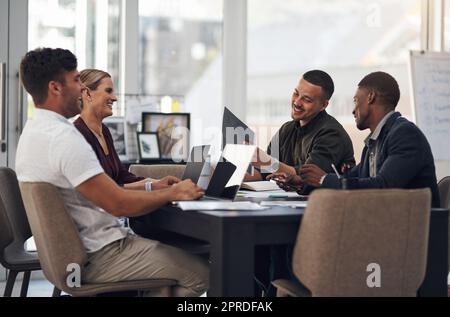 Le grandi aziende si sforzano di superare costantemente le aspettative attraverso il lavoro di squadra. Un gruppo di uomini d'affari che hanno una riunione in un ufficio. Foto Stock