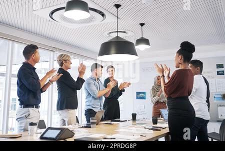 Risultati eccezionali tutto tondo. Un gruppo di uomini d'affari che batte durante una riunione in un ufficio moderno. Foto Stock