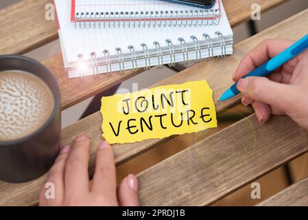 Scrittura visualizzazione del testo Joint Venture. Business idea Collaboration Arrangement parti Partnership Team donna d'affari che tiene la penna e indica un messaggio importante. Foto Stock