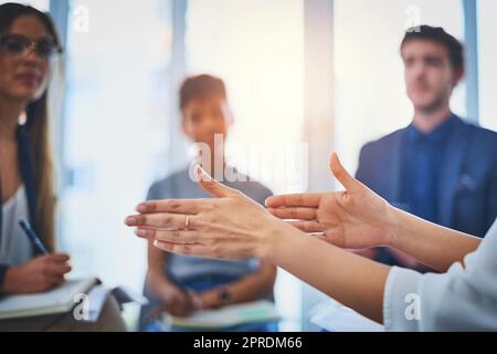 Spiega con attenzione la sua nuova idea al team. Primo piano di una donna d'affari irriconoscibile che si muove con le mani durante un incontro con i suoi colleghi al lavoro. Foto Stock