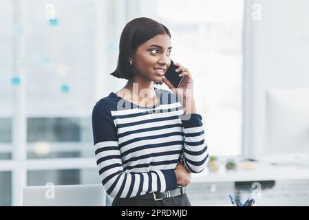 Cercate sempre di essere aperti a nuove possibilità. Una giovane donna d'affari che effettua telefonate nel suo ufficio. Foto Stock