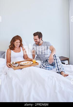 È stato il mio turno sorprendervi con qualcosa di dolce: Una coppia che si è goduto la colazione a letto insieme a casa. Foto Stock