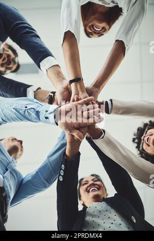 Le mani impilate e impilate mostrano l'unità, la forza o la motivazione del team tra i colleghi aziendali creativi dal basso. Un gruppo di persone d'affari entusiaste, sorridenti e aggrovigliate, pronte al successo Foto Stock