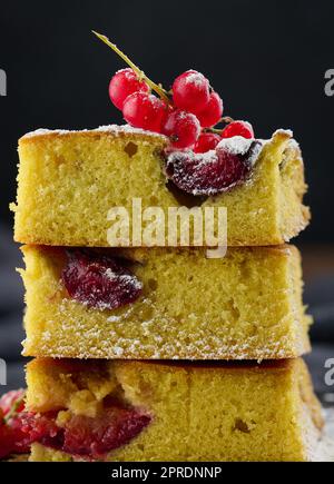 Una pila di fette quadrate di torta al biscotto di susina al forno, cosparse di zucchero a velo sulla parte superiore Foto Stock