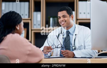 Medico che parla al paziente di diagnosi o assistenza sanitaria a un appuntamento o all'interno di uno studio clinico. Medico maschio professionista sorridente che dà buoni consigli al cliente nella consultazione di controllo Foto Stock