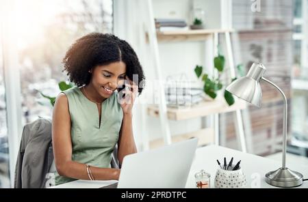 Lascilo dare un'occhiata per voi. Una giovane donna d'affari attraente che fa una telefonata mentre lavora alla sua scrivania nell'ufficio. Foto Stock