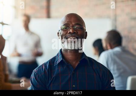 Uomo d'affari maturo seduto in una riunione, conferenza o seminario in una sala riunioni con i colleghi al lavoro. Ritratto di primo piano del volto di un professionista senior, felice e aziendale in un workshop di formazione Foto Stock