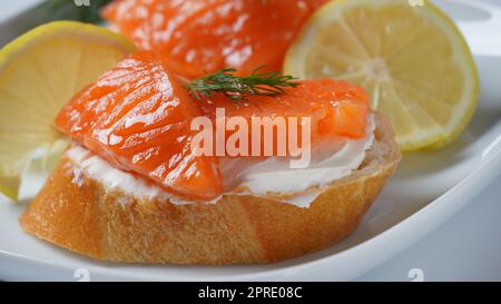 Panini aperti con filetto di trota, pane di grano con burro ed erbe aromatiche Foto Stock