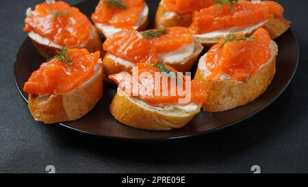 Panini aperti con filetto di trota, pane di grano con burro ed erbe aromatiche Foto Stock