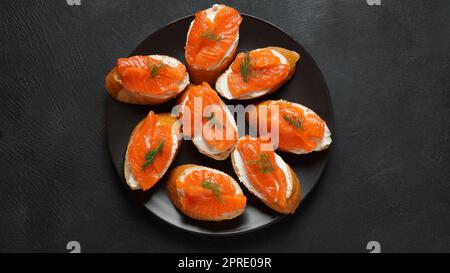 Panini aperti con filetto di trota, pane di grano con burro ed erbe aromatiche Foto Stock