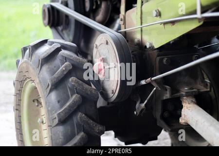 Tipico trattore diesel pesante con rimorchio. Mezzi di trasporto agricoli della campagna. Attrezzature agricole portatili, minitractor da passeggio. Il sistema di avviamento è meccanico e manuale. Foto Stock