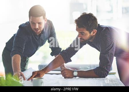 Ha bisogno solo di alcuni cambiamenti qui e là... due giovani designer che lavorano su progetti in un ufficio. Foto Stock