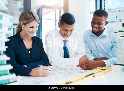 Architetto, costruttore e ingegnere che lavorano insieme come team di costruzione su piani e progetti nel loro studio di architettura. Architettura e design con un gruppo di uomini d'affari che discutono di lavoro Foto Stock