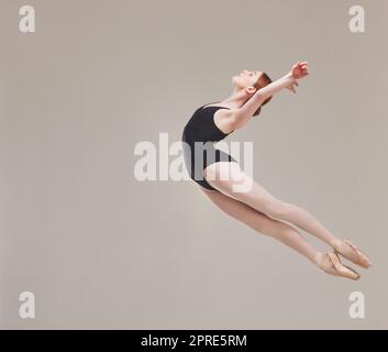 Ballerina ballerina danzante, allenarsi e saltare artisticamente in aria con flessibilità, fitness e performance. Esercizi di ballerina sana, di movimento e di talento per un atto classico in studio Foto Stock