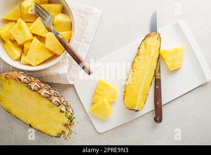 Ananas fresco affettato su sfondo bianco luminoso tavolo, vista dall'alto primo piano Foto Stock