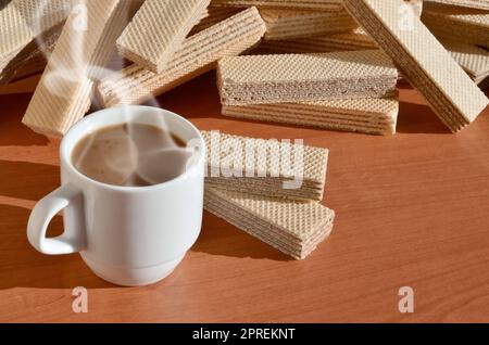 Una tazza di caffè caldo e una manciata di classico russo cialde con diversi riempimenti su un marrone la superficie di legno. Still-life di mattina festa, concetto s Foto Stock