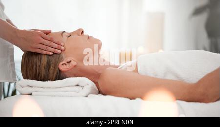 La sua mente si sente più chiara. una donna che riceve un massaggio al tempio in una spa Foto Stock