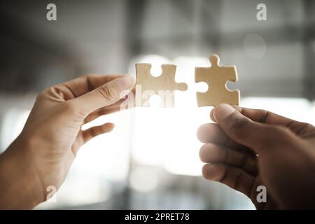 Lavoro di squadra, unità e crescita con pezzi puzzle nelle mani del personale aziendale che costruisce, cresce e lavora insieme come un team. Primo piano dei colleghi che mostrano insieme e sinergia dal basso Foto Stock