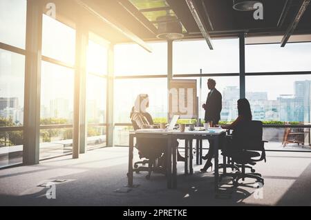 Con le aziende di successo, c'è un team aziendale dietro a tutto. Gli uomini d'affari aziendali hanno una riunione nella sala riunioni. Foto Stock