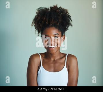 Capelli naturali, cura di dont. Studio shot di una bella, fresca di fronte giovane donna in posa su uno sfondo verde. Foto Stock