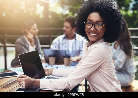 Weve condividevano nuove prospettive. Ritratto di una giovane donna d'affari che ha un incontro con i suoi colleghi in un bar. Foto Stock