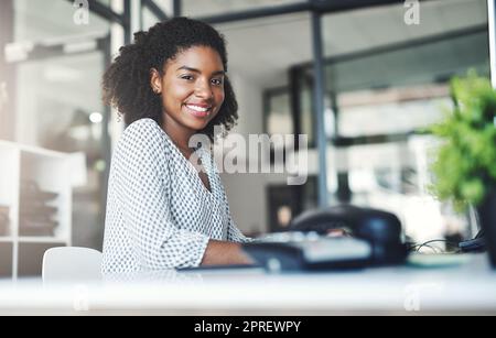 È stata una giornata intensa ma di successo. Ritratto di una giovane donna d'affari che lavora su un computer in un ufficio. Foto Stock