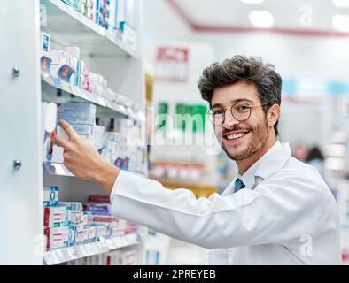 Mantenendo i suoi scaffali ben riforniti. Ritratto di un farmacista che lavora in farmacia. Foto Stock