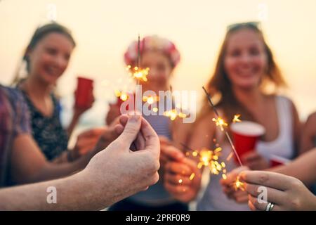 Un po' di scintilla nella giornata. Giovani che si aggrappano in spiaggia. Foto Stock