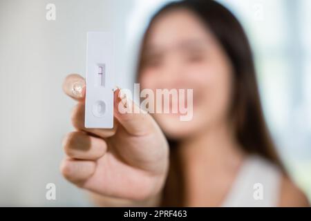 Donna in primo piano che mostra il kit per test antigenico rapido per autotest con risultato negativo Foto Stock