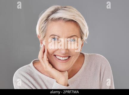 Cura della pelle, bellezza e donna anziana felice o modello viso con denti sani che danno un sorriso su un ritratto in studio alla testa. Chirurgia odontoiatrica, benessere e estetica per le donne anziane per rimanere belle Foto Stock