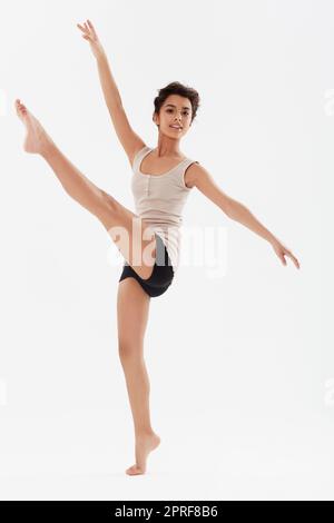 Ne esce uno con la musica. Una bella donna etnica che balla su uno sfondo bianco Foto Stock