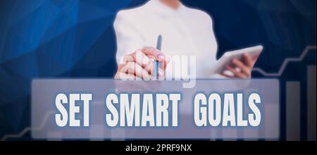 Set di testo per calligrafia Smart Goals. Word for Establish Achievable Objects Crea buoni piani aziendali uomo d'affari che possiede un telefono cellulare con messaggi importanti e vi indica Foto Stock