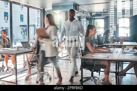 Ufficio pieno di impegni con un team produttivo di dipendenti che lavorano sodo e velocemente per completare attività e progetti. Colleghi, colleghi o uomini d'affari che lavorano in un ambiente di lavoro moderno sono creativi Foto Stock