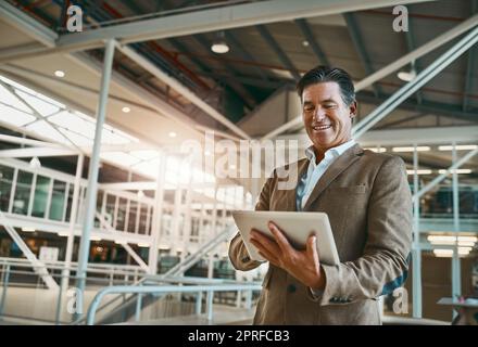 capo felice buon lavoro. un uomo d'affari maturo in ufficio e che prende appunti sul suo tablet per l'azienda. Foto Stock