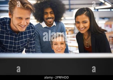 Un team di progettisti che lavorano insieme su un computer nel proprio ufficio. Foto Stock